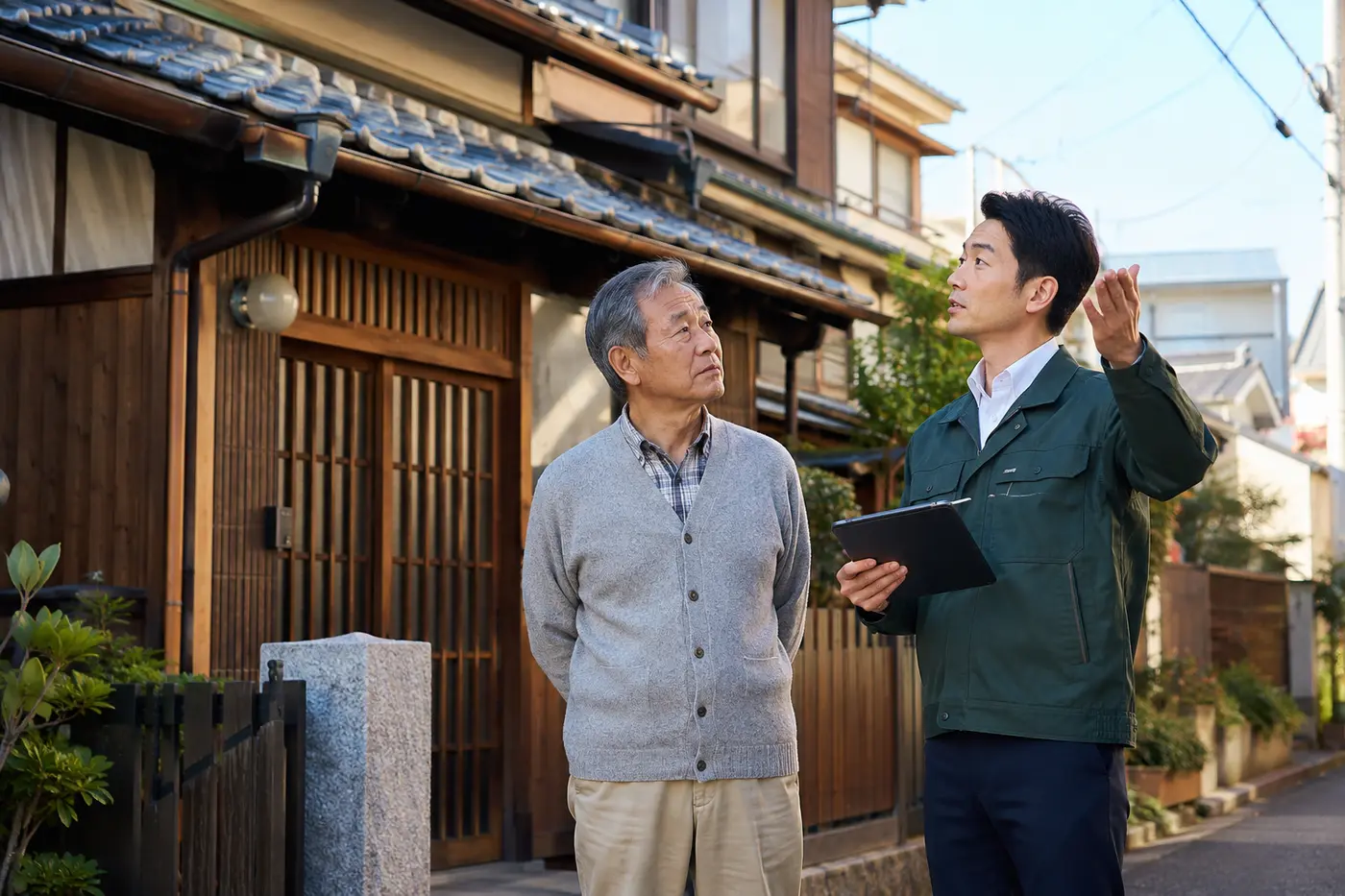 関西の木造住宅前で点検内容を説明するスタッフの対応イメージ